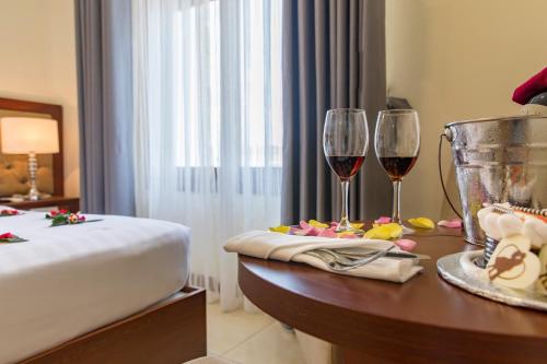a hotel room with two glasses of wine on a table at Apus Hotel in Nha Trang