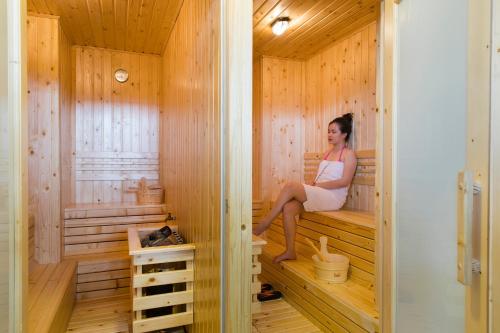 a woman is sitting in a sauna at Apus Hotel in Nha Trang