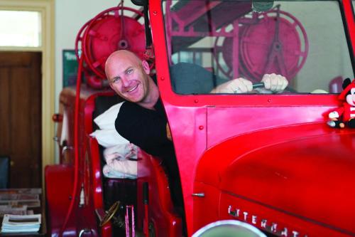 a man sitting inside of a red fire truck at Fire Station Inn in Adelaide