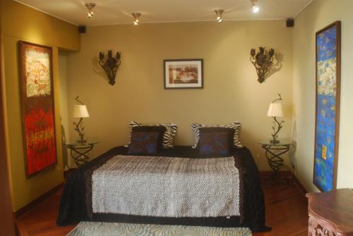 1 dormitorio con 1 cama y 2 lámparas en la pared en Black Shark Apartments, en Lima