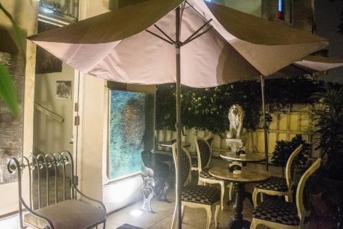 a table and chairs with an umbrella in a room at Casa Falleri Boutique Hotel in Lima