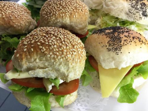 four hamburgers with cheese and lettuce on a plate at B&B Le Vie D'Arte in Agrigento
