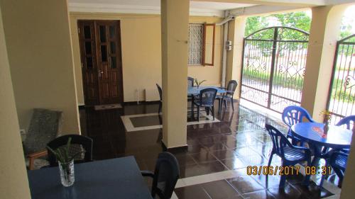 a dining room with tables and chairs and a balcony at Sunny house Kobuleti in K'obulet'i