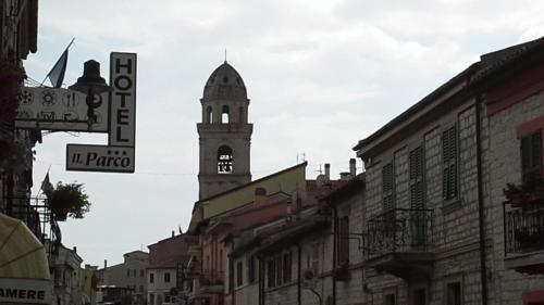 ein Gebäude mit einem Uhrturm auf einer Stadtstraße in der Unterkunft Hotel Il Parco Sirolo in Sirolo