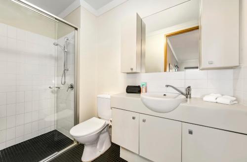a bathroom with a toilet and a sink and a shower at Quest on Rheola in Perth