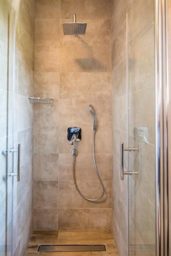 a shower with a shower head in a bathroom at Apartments Sun in Zadar