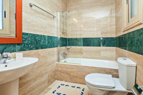 a bathroom with a toilet and a sink and a tub at Villa Lalianda Sandy Beach Villas - Private Pool - Jacuzzi - Private Beach Area in Polis Chrysochous