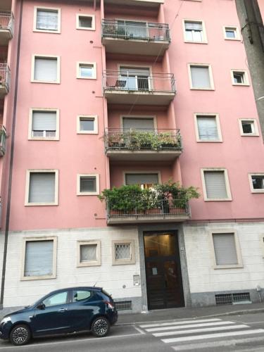 a car parked in front of a pink building at A casa mia in Saronno