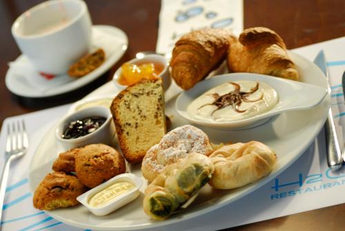 a plate of food with pastries and a cup of coffee at Kos Aktis Art Hotel in Kos Town