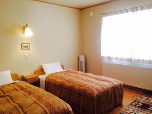 Habitación de hotel con 2 camas y ventana en Forestlodge Subaru, en Teshikaga
