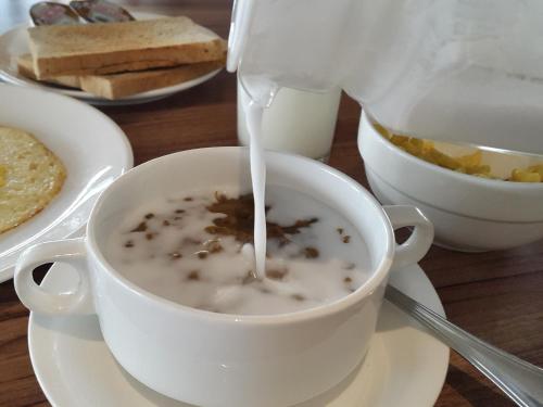 a person is pouring milk into a cup of coffee at Ayaka Suites in Jakarta