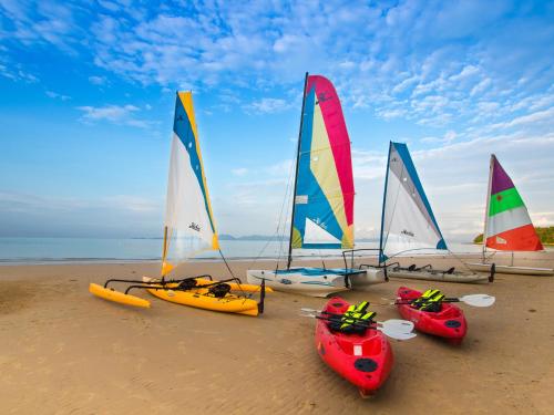 
a number of surfboards on a beach near a body of water at Dusit Thani Krabi Beach Resort - SHA Extra Plus in Klong Muang Beach
