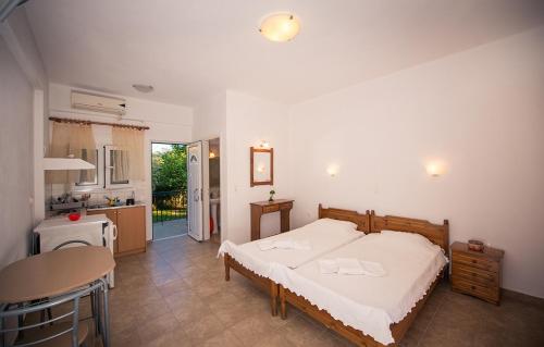 1 Schlafzimmer mit einem großen Bett und einer Küche in der Unterkunft Lemi Apartments in Rizá