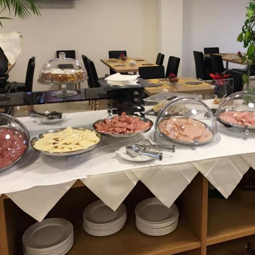 une longue table avec de nombreux plats dans l'établissement Hotel Novarello, à Granozzo con Monticello