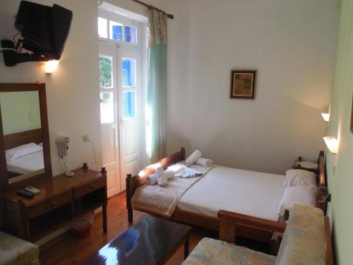 a small bedroom with a bed and a mirror at Adonis Rooms in Skopelos Town
