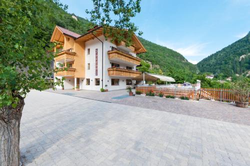 un grande edificio con montagne sullo sfondo di Gasthof Zur Sonne a Cardano