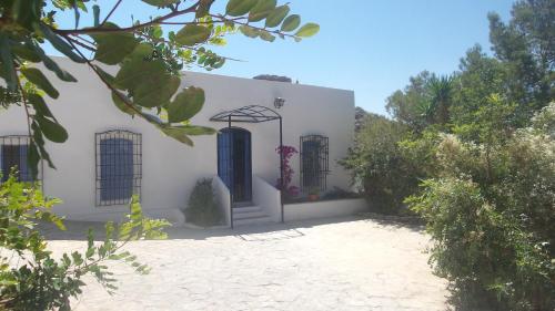 Casa blanca con puertas y árboles azules en Casa Rural La Fuensanta, en Mojácar