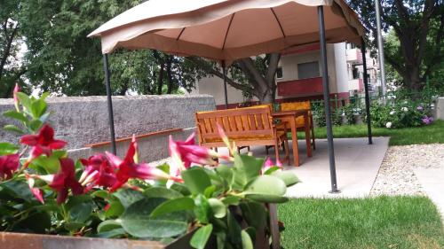 a table and chairs under an umbrella in a garden at Garden apartment Vanya in Split