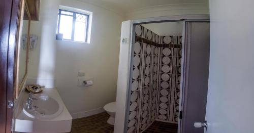 a bathroom with a sink and a toilet at Arabella Motor Inn (formerly South Tweed Motor Inn) in Tweed Heads