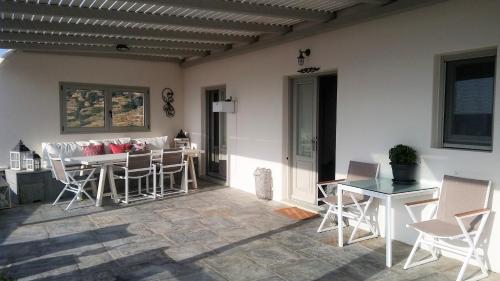a patio with a table and chairs and a dining room at Villa Baya in Ios Chora