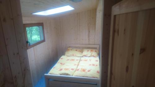 Cama en habitación pequeña con ventana en Chata Česká Kubice, en Česká Kubice