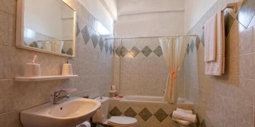 a bathroom with a sink and a toilet and a shower at Hotel Galaxias in Gouvia