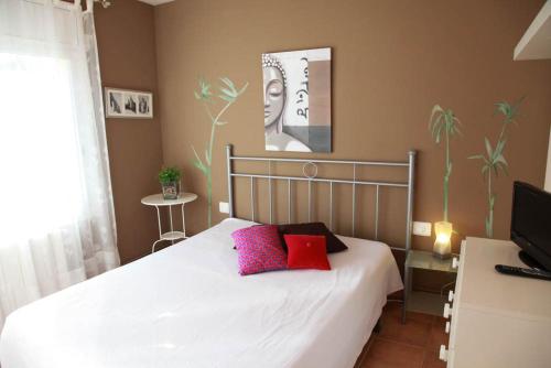 a bedroom with a bed with red and pink pillows at Laquilla II in Platja  d'Aro