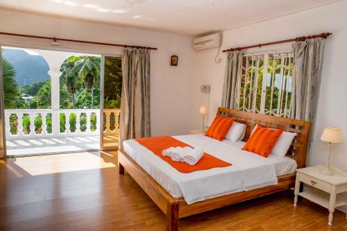 a bedroom with a bed and a large window at The Orchard Holiday Home in Mahe