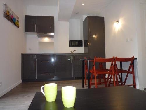 - une cuisine avec une table et deux tasses dans l'établissement La Loge, à Nice