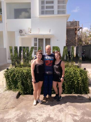 a man and two women standing in front of a house at Wika Bali Beach House in Jimbaran