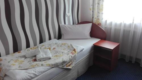 a small bedroom with a bed with a night stand at Artix in Zbąszynek