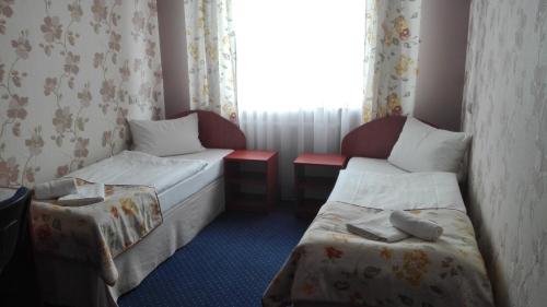 um quarto de hotel com duas camas e uma janela em Artix em Zbąszynek