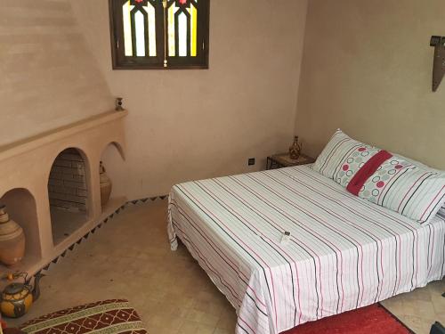 a small bedroom with a bed and a fireplace at Atlas Resorts in Aït Ourir