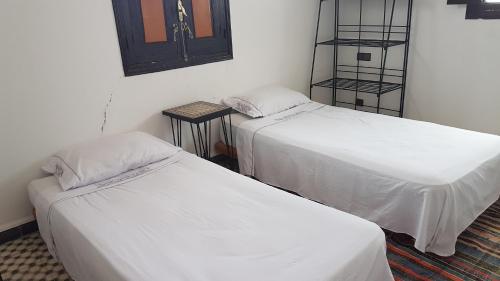 two beds in a room with white sheets at Atlas Resorts in Aït Ourir