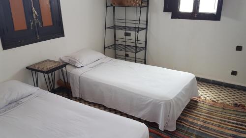 a room with two beds and a book shelf at Atlas Resorts in Aït Ourir