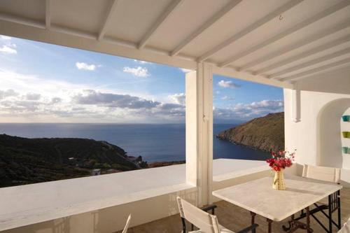 balcón con mesa y vistas al océano en Patmos Exclusive Villas, en Skala