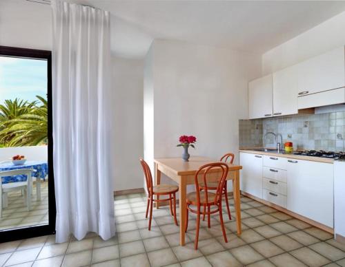 a kitchen with a table and chairs and a table at Al Pozzo Residence in Capoliveri