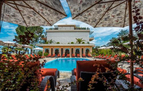 a pool at a resort with chairs and umbrellas at Dream Land Oasis in Chakvi