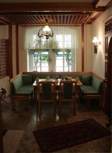 a dining room with a table and green chairs at Hotel Sächsischer Hof in Chemnitz