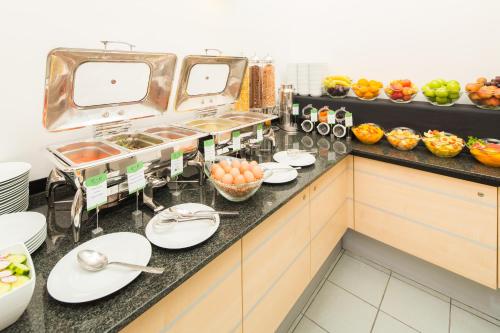 a kitchen counter filled with lots of different types of food at Exe City Park Hotel in Prague