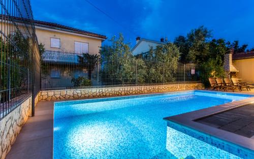 a swimming pool in front of a house at Pansion Tina in Šilo