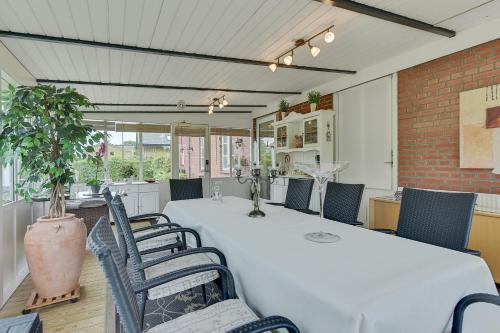 a dining room with a white table and chairs at Kollund Rooms in Kollund Østerskov