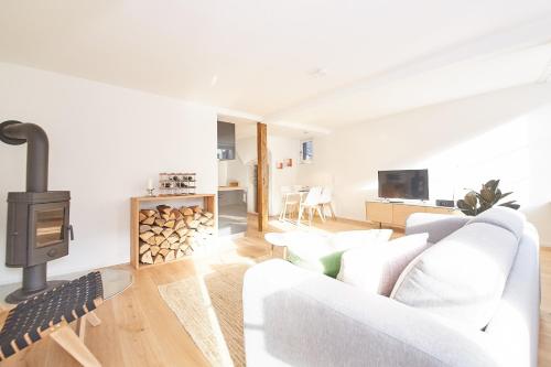 ein Wohnzimmer mit einer weißen Couch und einem Holzofen in der Unterkunft Zehn in Bernkastel-Kues