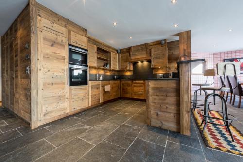Una cocina con gabinetes de madera y un horno de estufa. en La Cordée 4 - Spa Access - Mer de Glace complex, en Nendaz