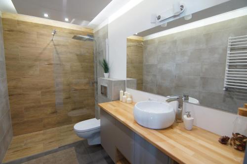 Un baño con lavabo, inodoro y ducha. en Apartament Kropla Bałtyku 16 Darłówko, en Darłówko