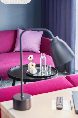 a living room with a pink couch and a table at Best Western Plus Hotel Fredericia in Fredericia