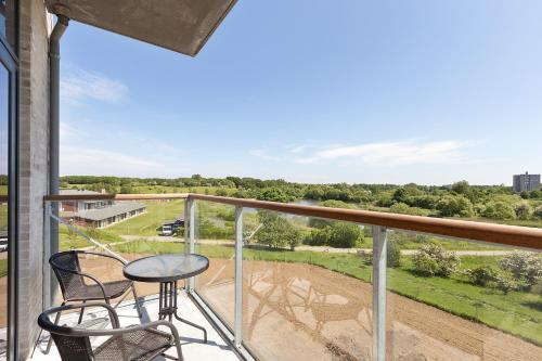 a balcony with a table and chairs and a view of a field at Best Western Plus Hotel Fredericia in Fredericia