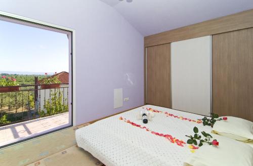 sypialnia z łóżkiem i dużym oknem w obiekcie Apartment Mihanovic w mieście Žrnovnica