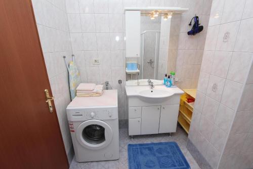 łazienka z pralką i umywalką w obiekcie Apartments Marlina w Rovinj