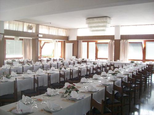 a room filled with tables and chairs with white tablecloths at Hotel Valle Intelvi in San Fedele Intelvi